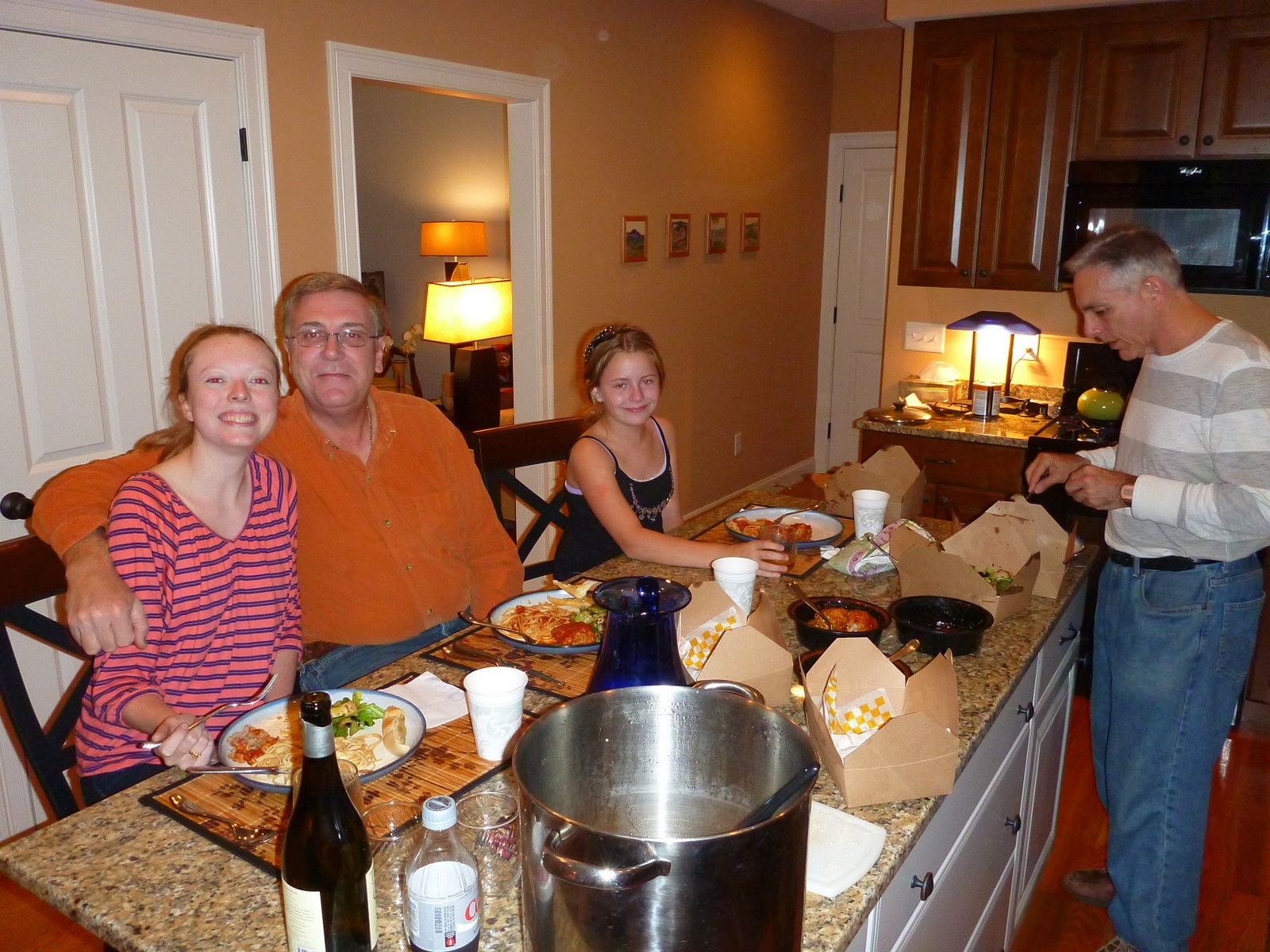 Family gathered around a kitchen island with Alan