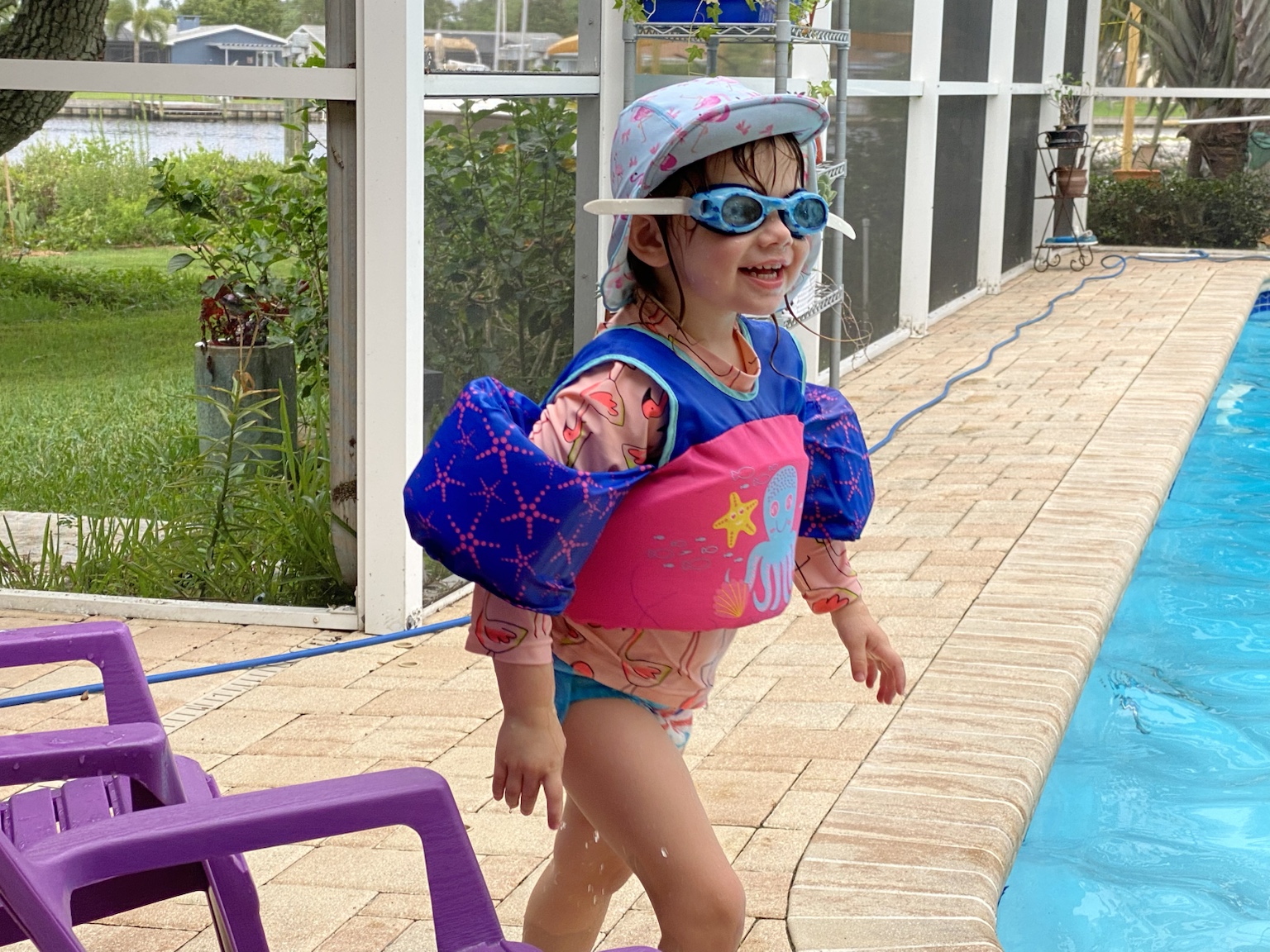 Ready for another pool day in bright floaties and a sun hat.