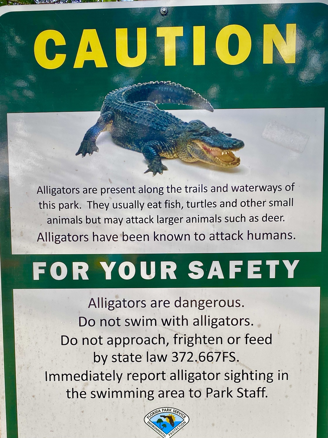 A posted alligator-safety notice reminding visitors not to approach, feed, or disturb the animals.