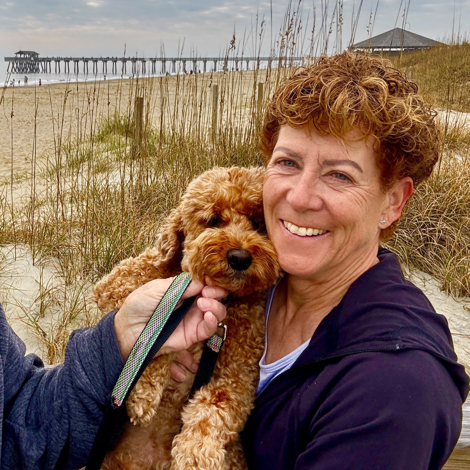 Dune snuggles near the pier — Buddyboy allowing Kym to share his beach moment.