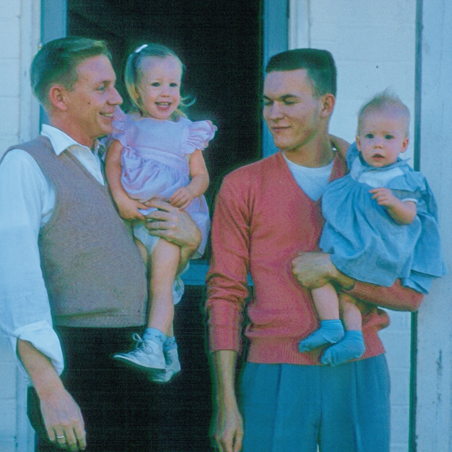Two proud dads holding the little ones.