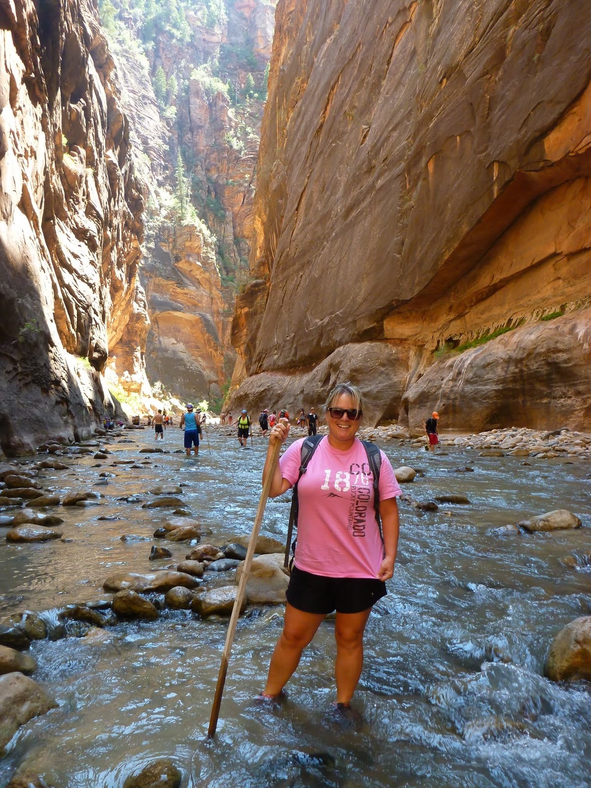 Cindy surrounded by tall sandstone walls and reflected light.