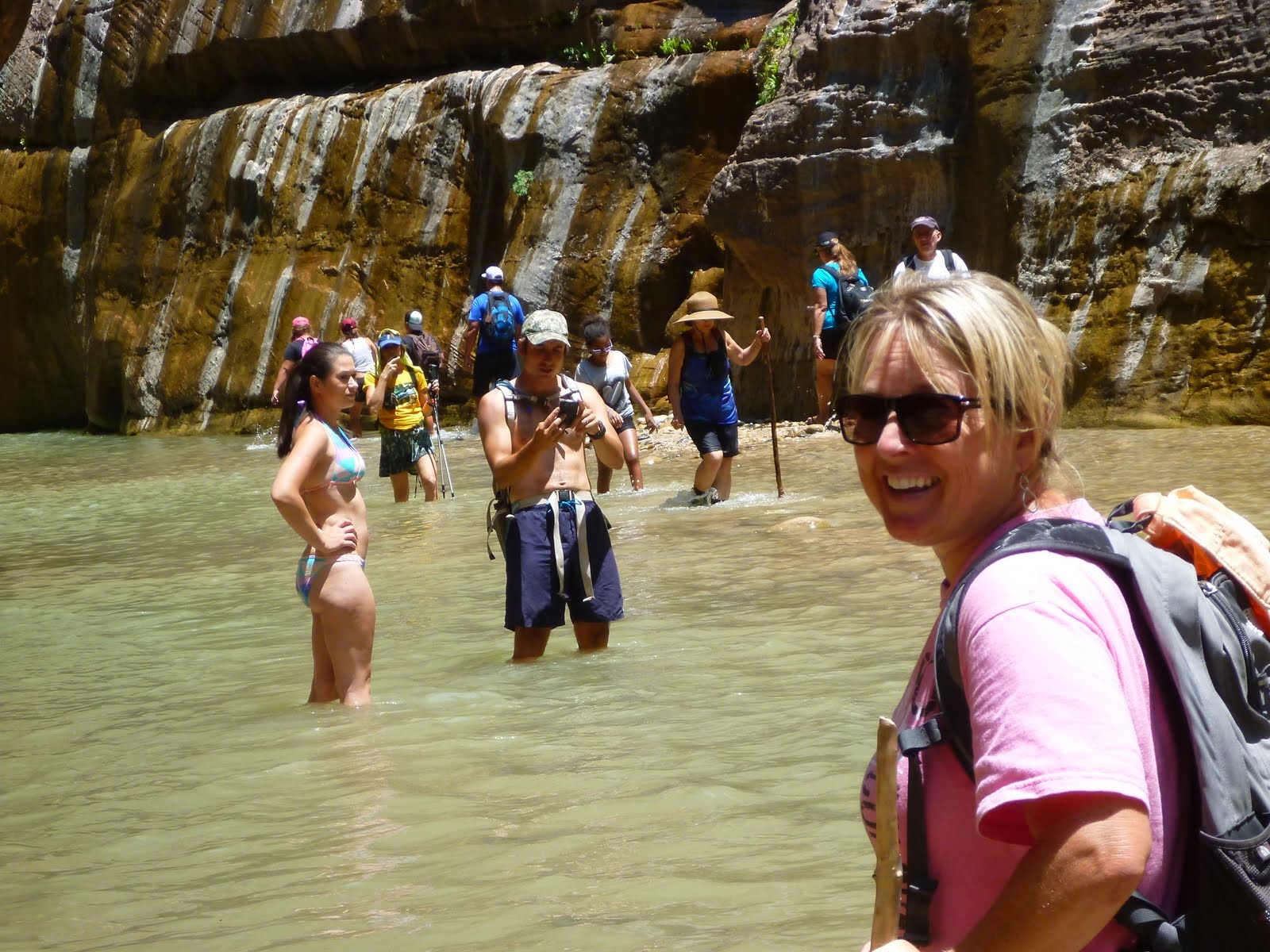 Cindy beside one of the wet canyon walls where water seeps over the sandstone.
