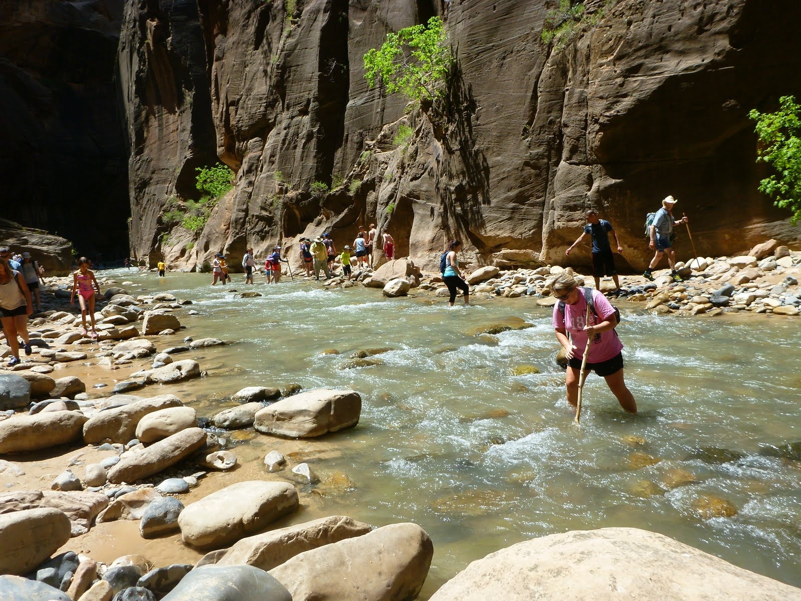 Cindy carefully choosing each step across uneven river stones.