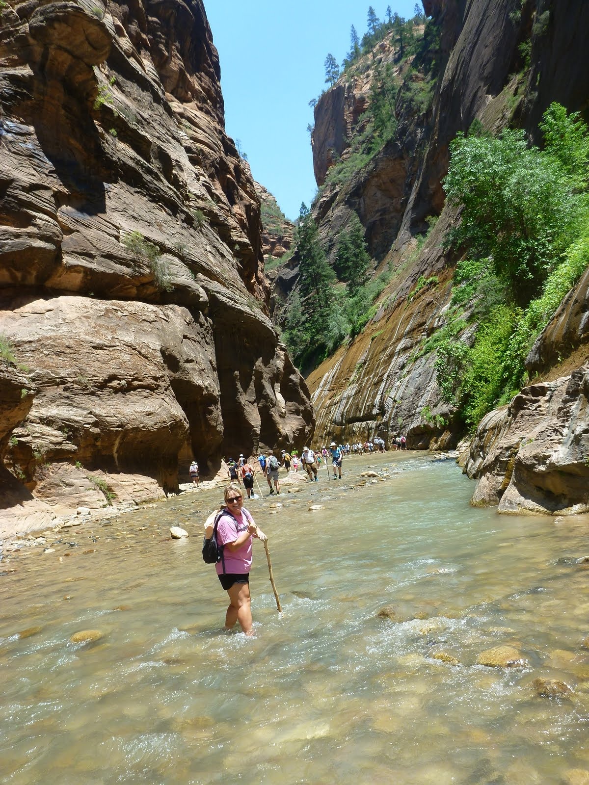 Cindy wading upstream beneath the rising canyon walls.