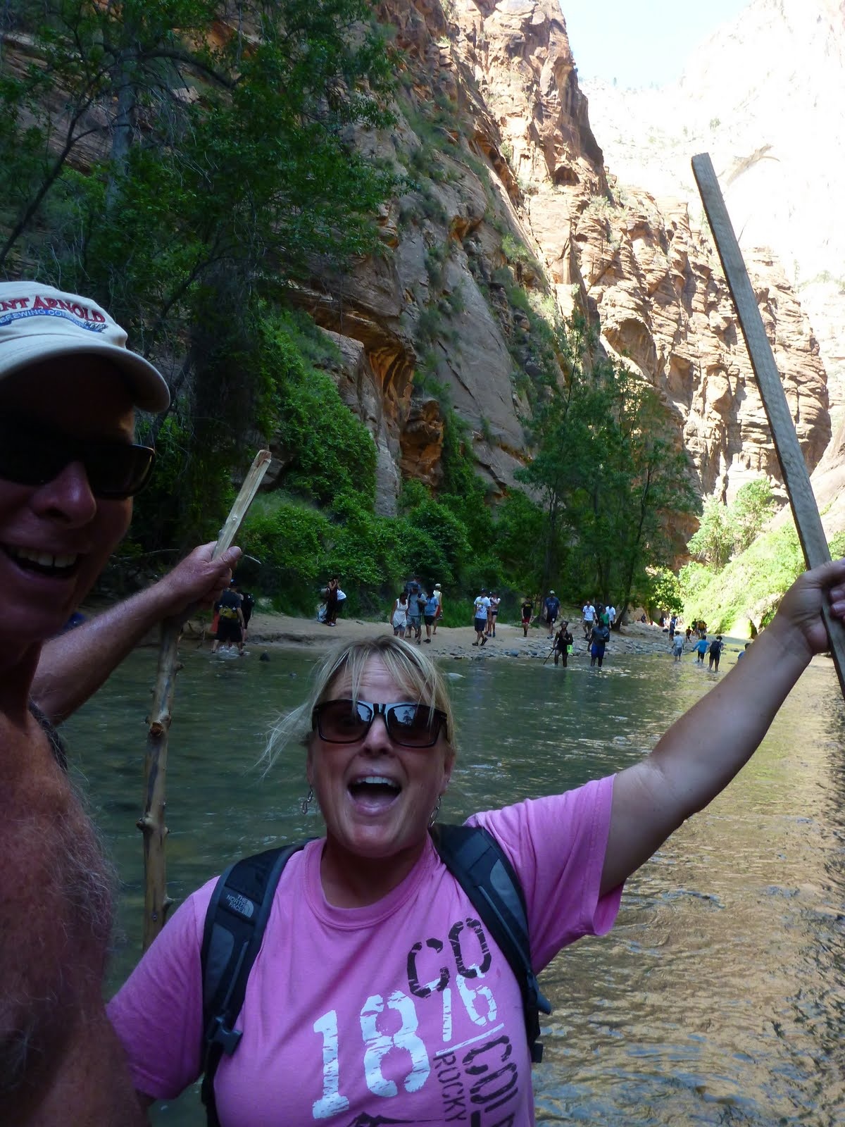 Cindy waving beneath a steep canyon wall.