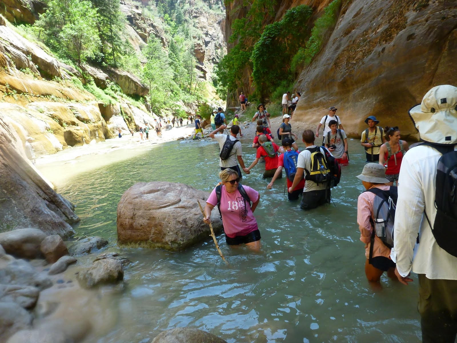 Hikers moving through one of the deeper sections of the Virgin River.