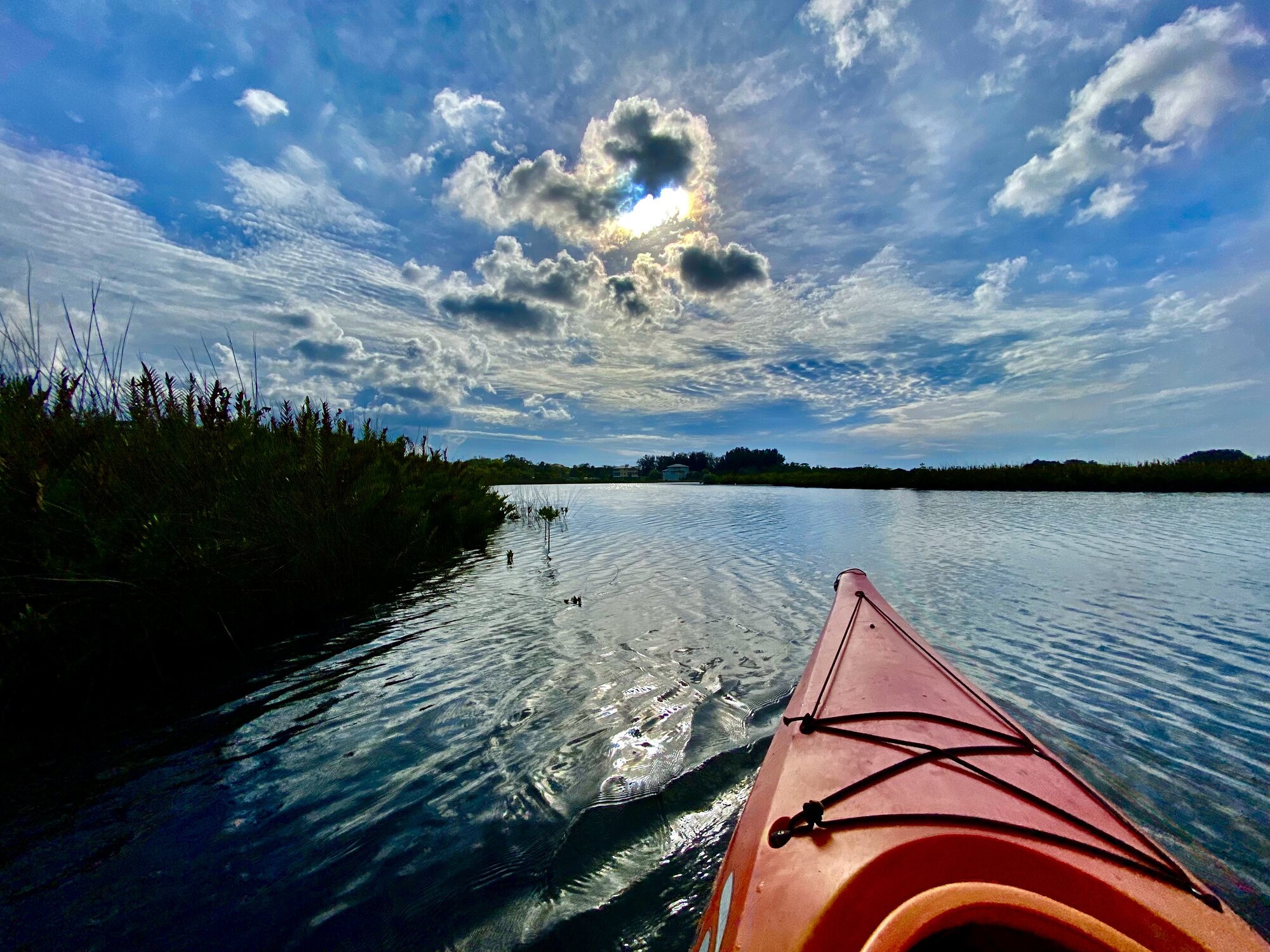 Kayak bow paddling toward bright sky