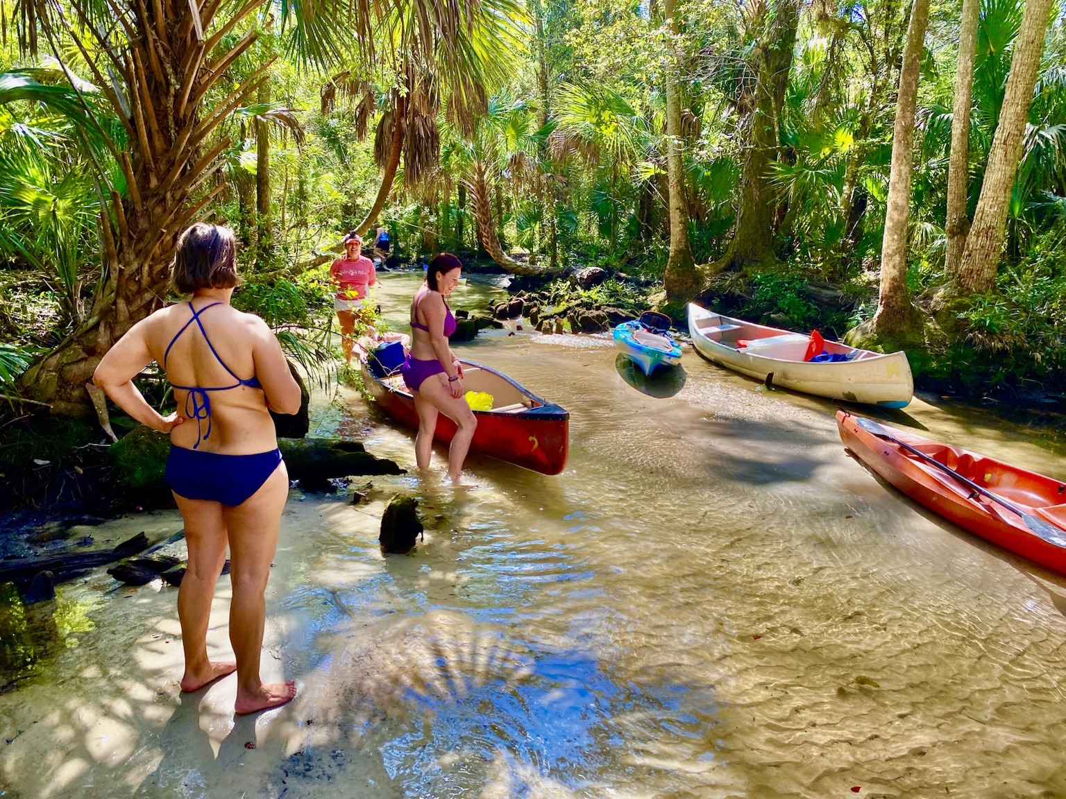 Boats pulled into a shaded sandy stop along the spring run.