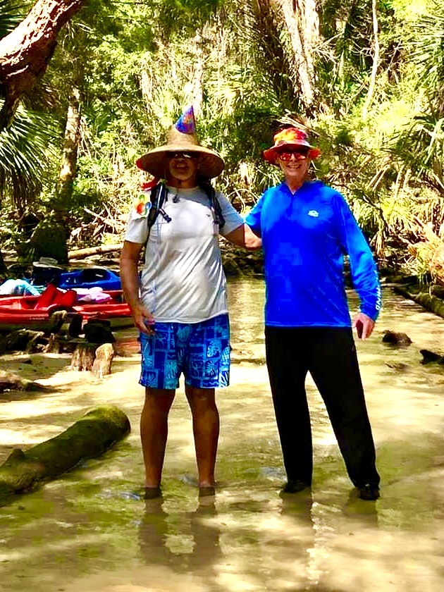Layne posing with a friend in the cool shallows beneath the trees.