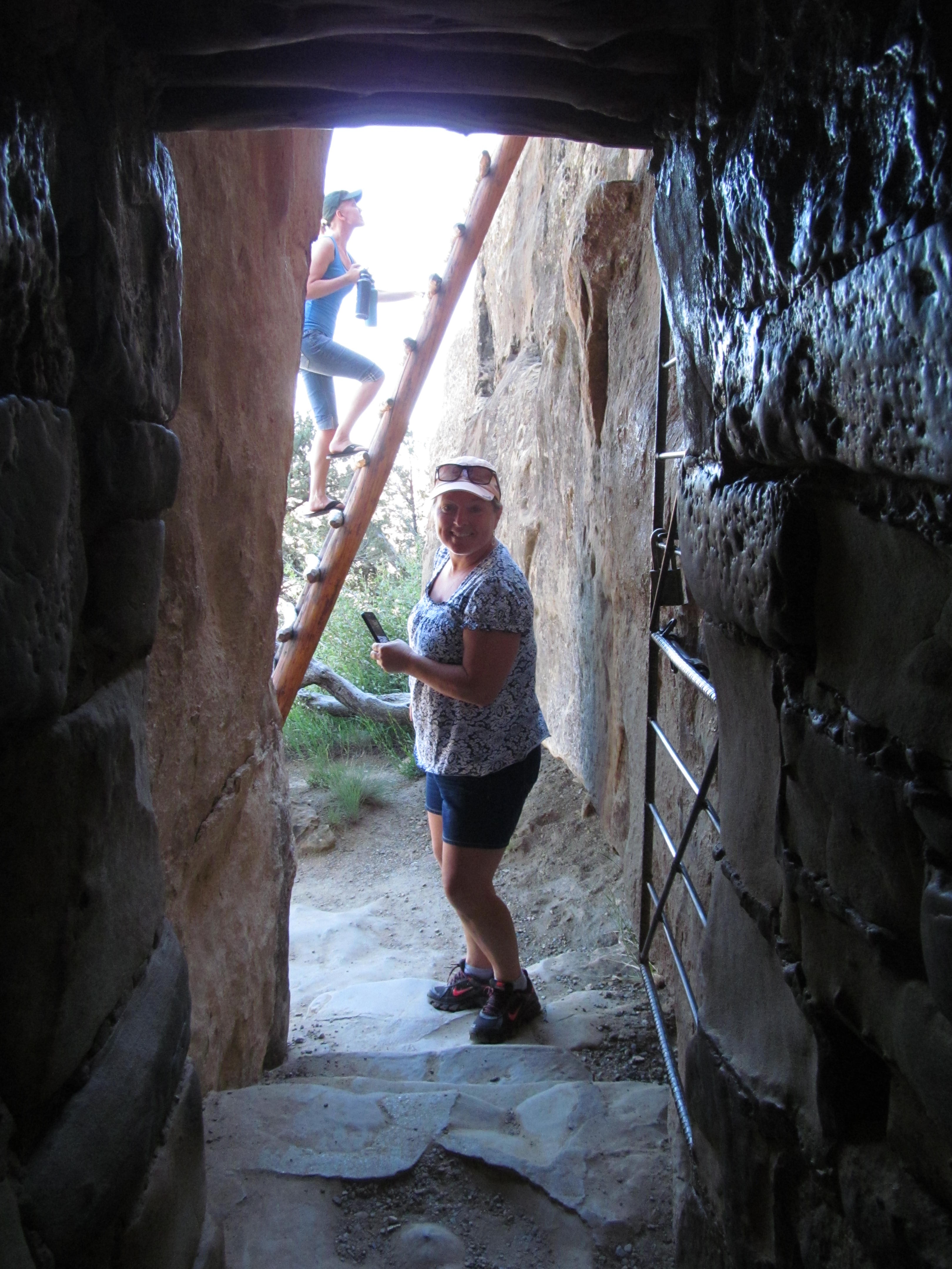 Cindy standing in the light at the end of a dark stone passage.