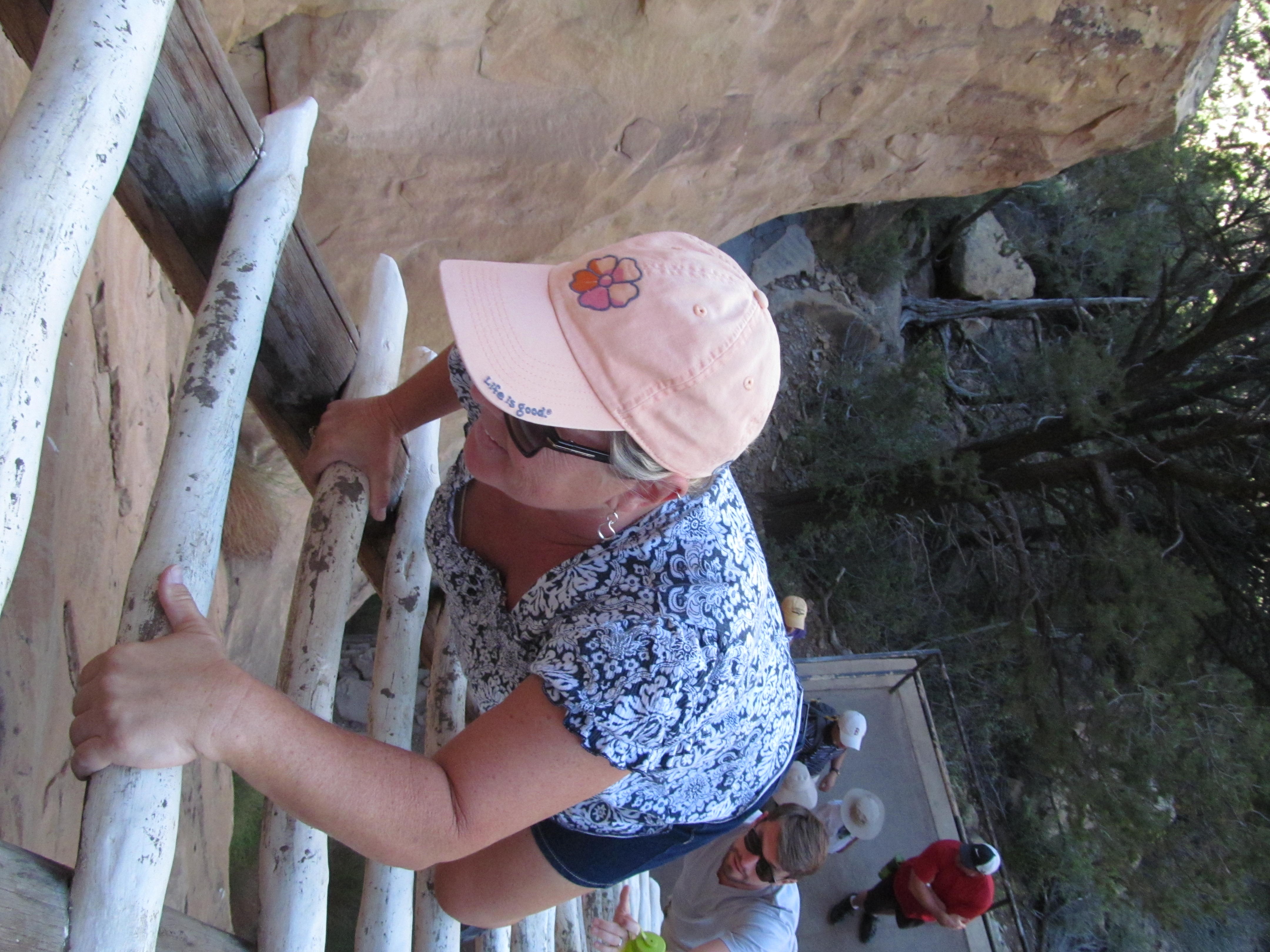 Cindy climbing one of the wooden ladders used to enter a Mesa Verde cliff dwelling.