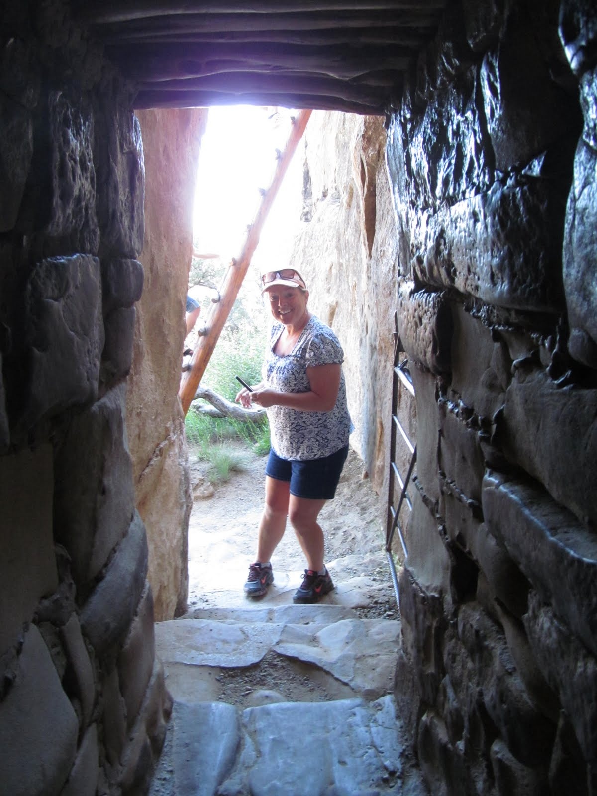 Cindy stepping through one of the compact doorways used by the ancestral residents.