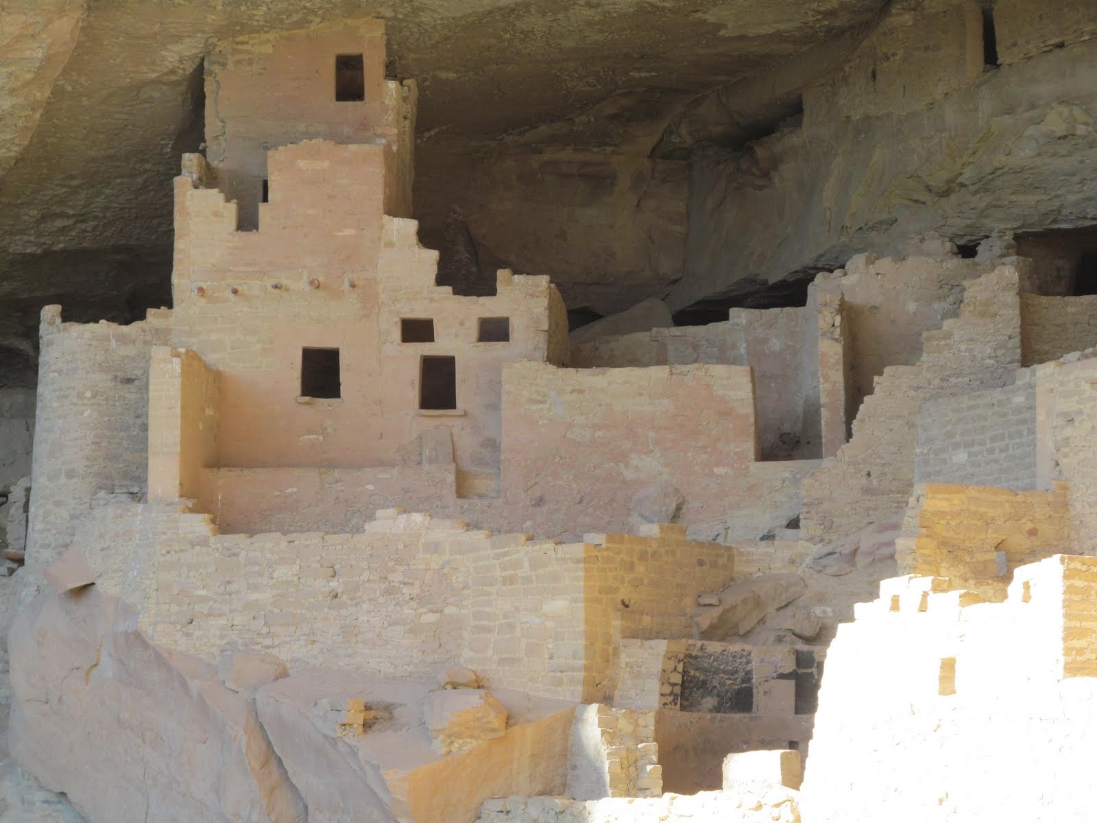 Sunlight illuminating the pale masonry deep inside Cliff Palace.