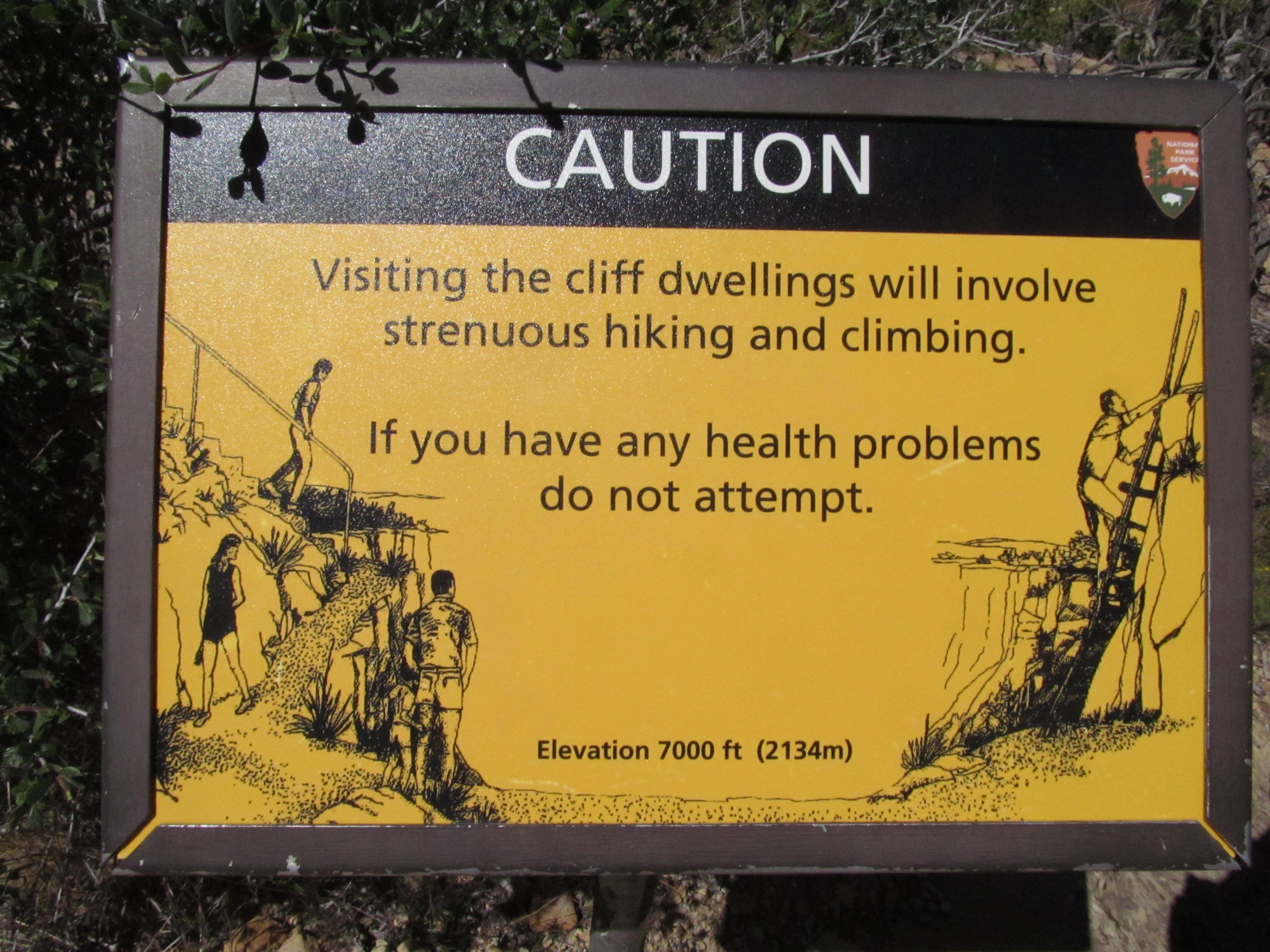 A warning sign before the steep ladders and narrow passages leading into a Mesa Verde cliff dwelling.