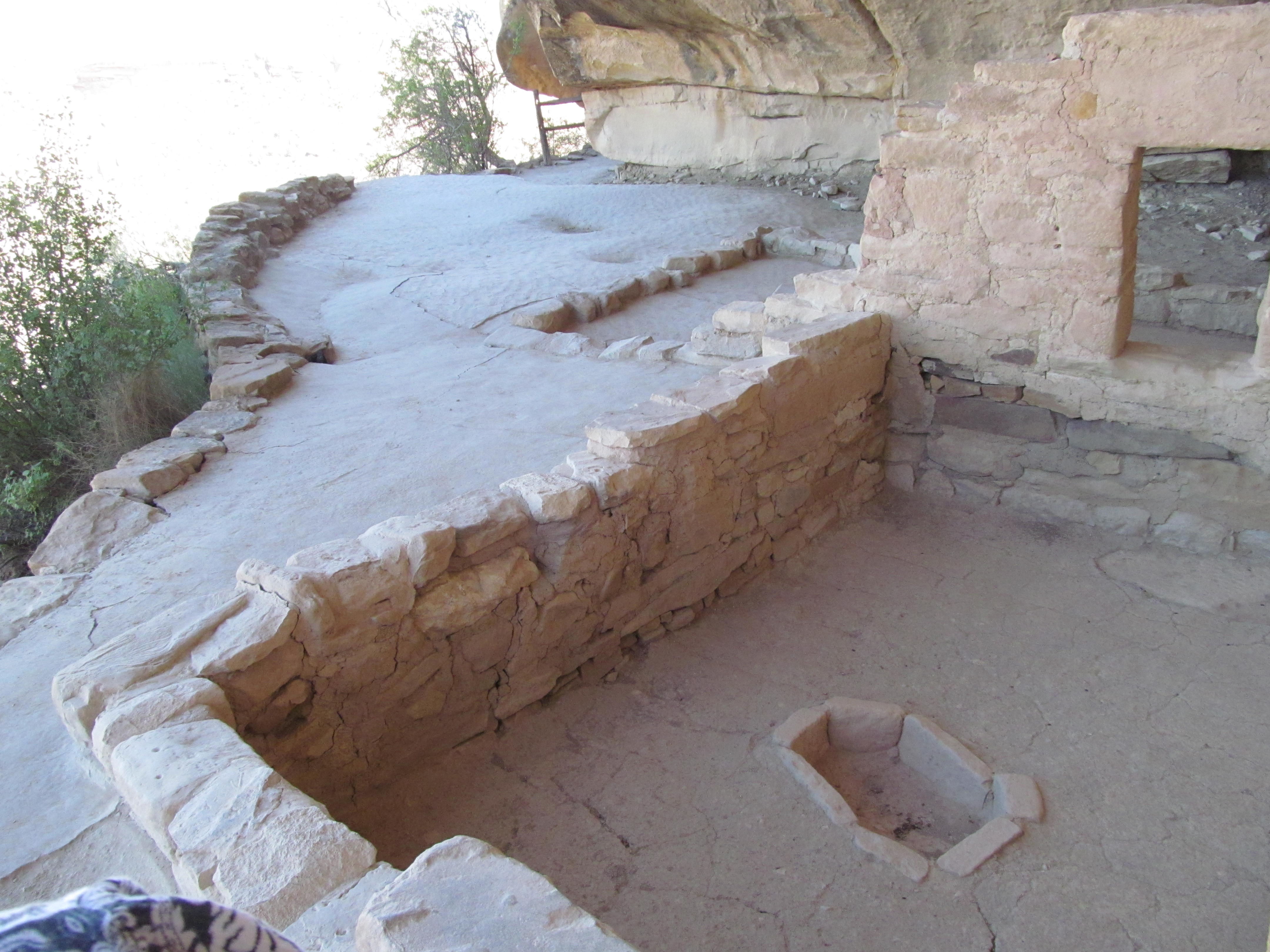 A kiva and adjoining courtyard tucked beneath the protective rock alcove.