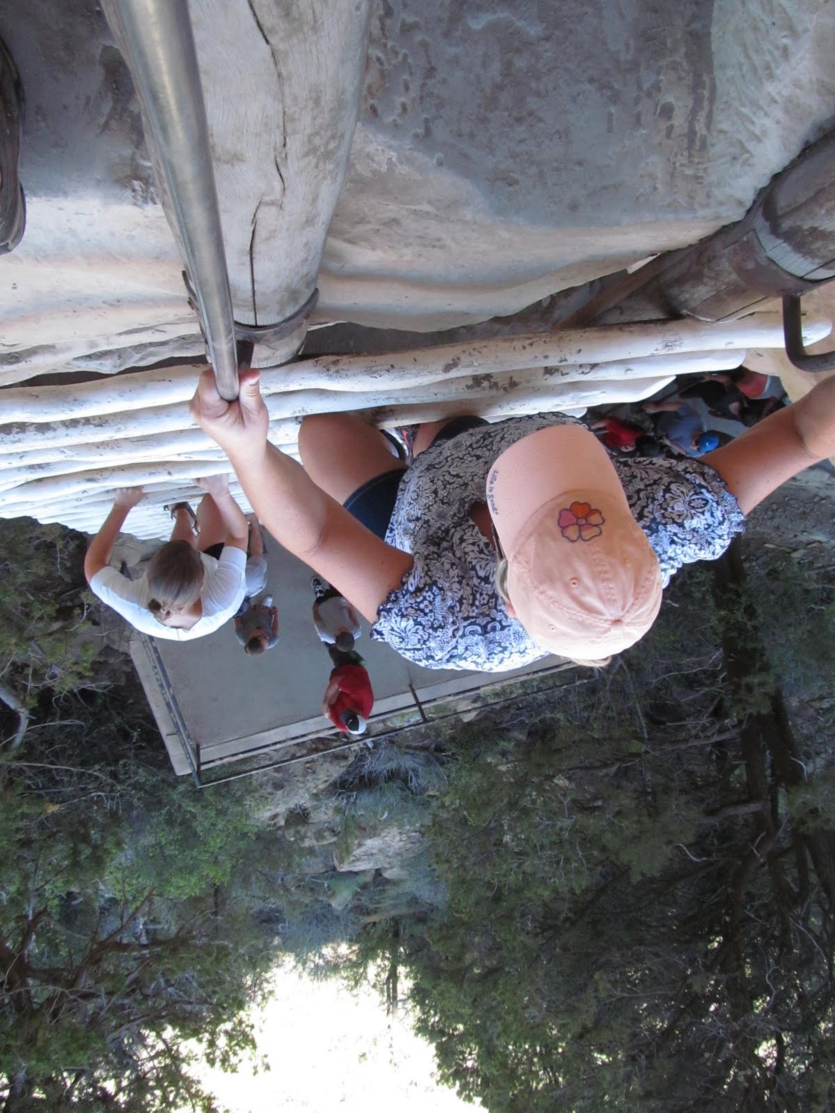 Visitors making the careful ladder climb into the alcove at Mesa Verde.