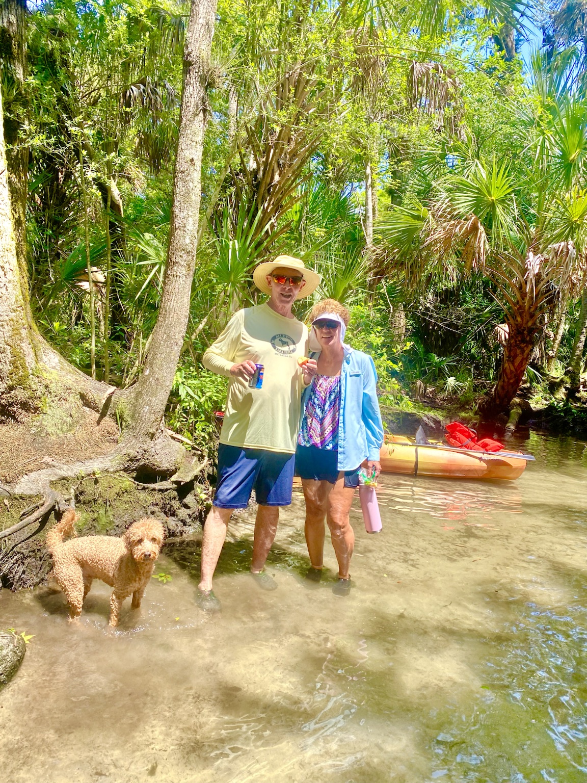 Tim, Kym, and Buddyboy cooling off beside their kayaks in a shady Florida spring run.
