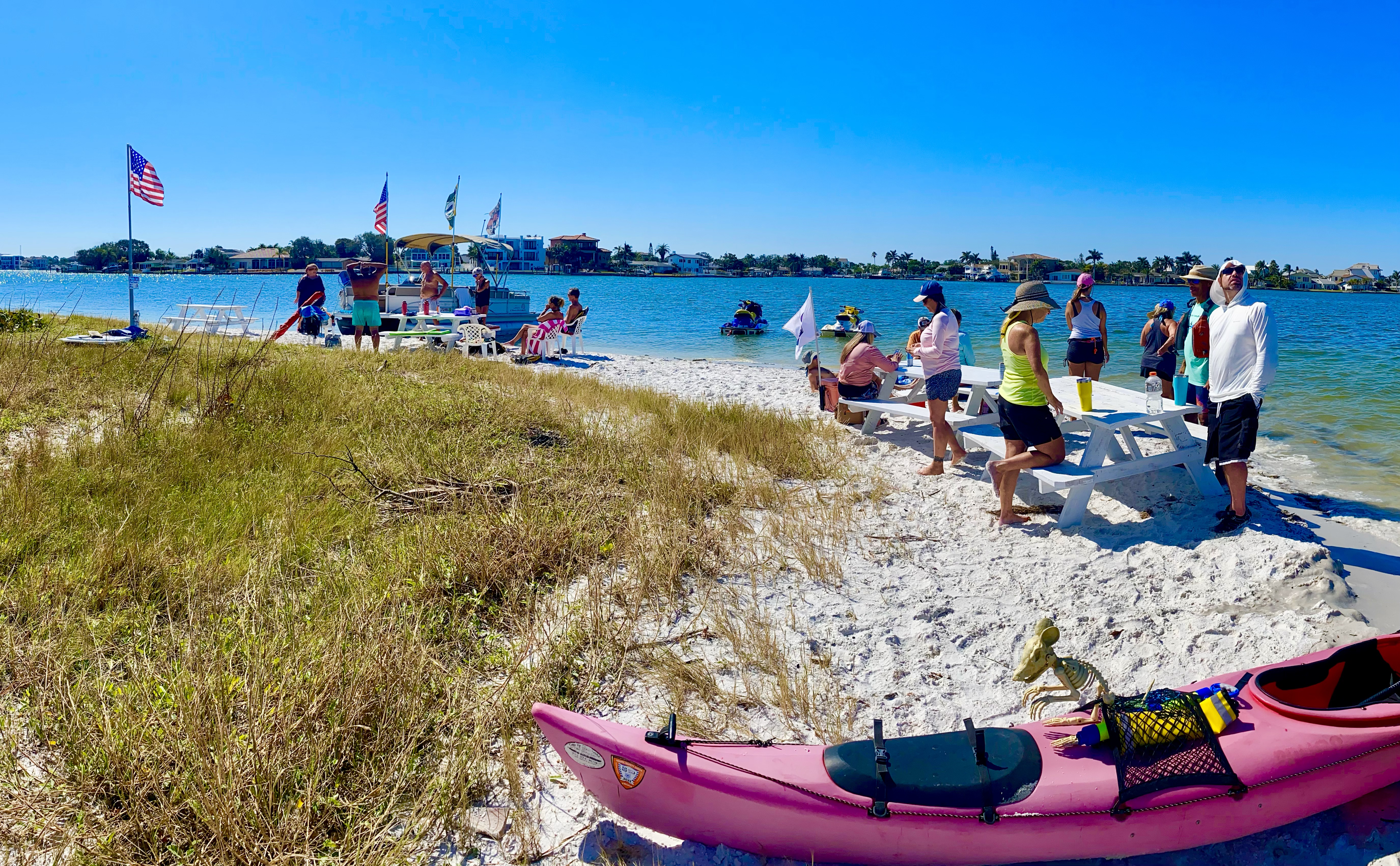 The group spreads out along the sandy shoreline of Buccaneer Island.