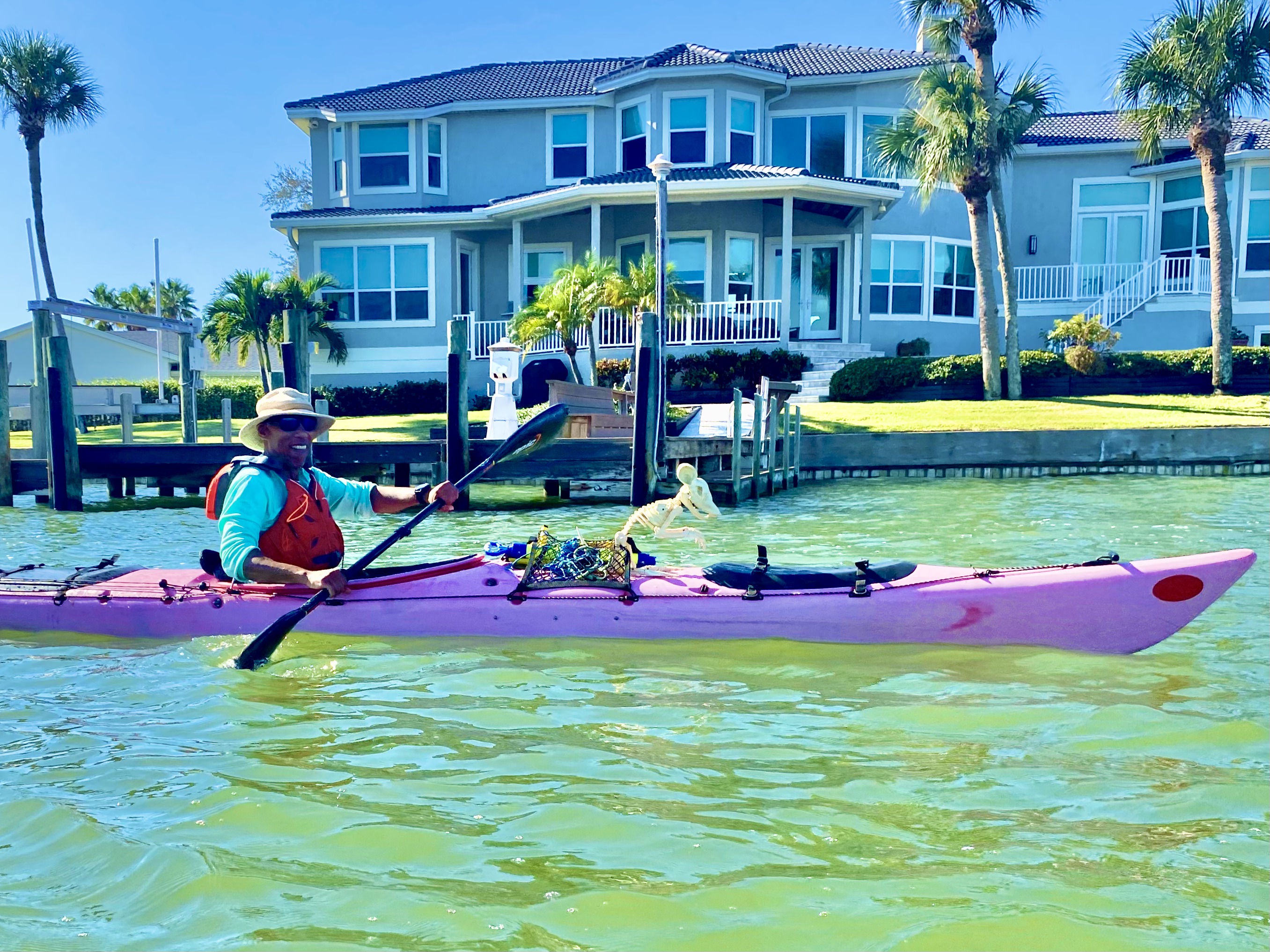 A paddler glides past the waterfront homes along the protected shoreline.