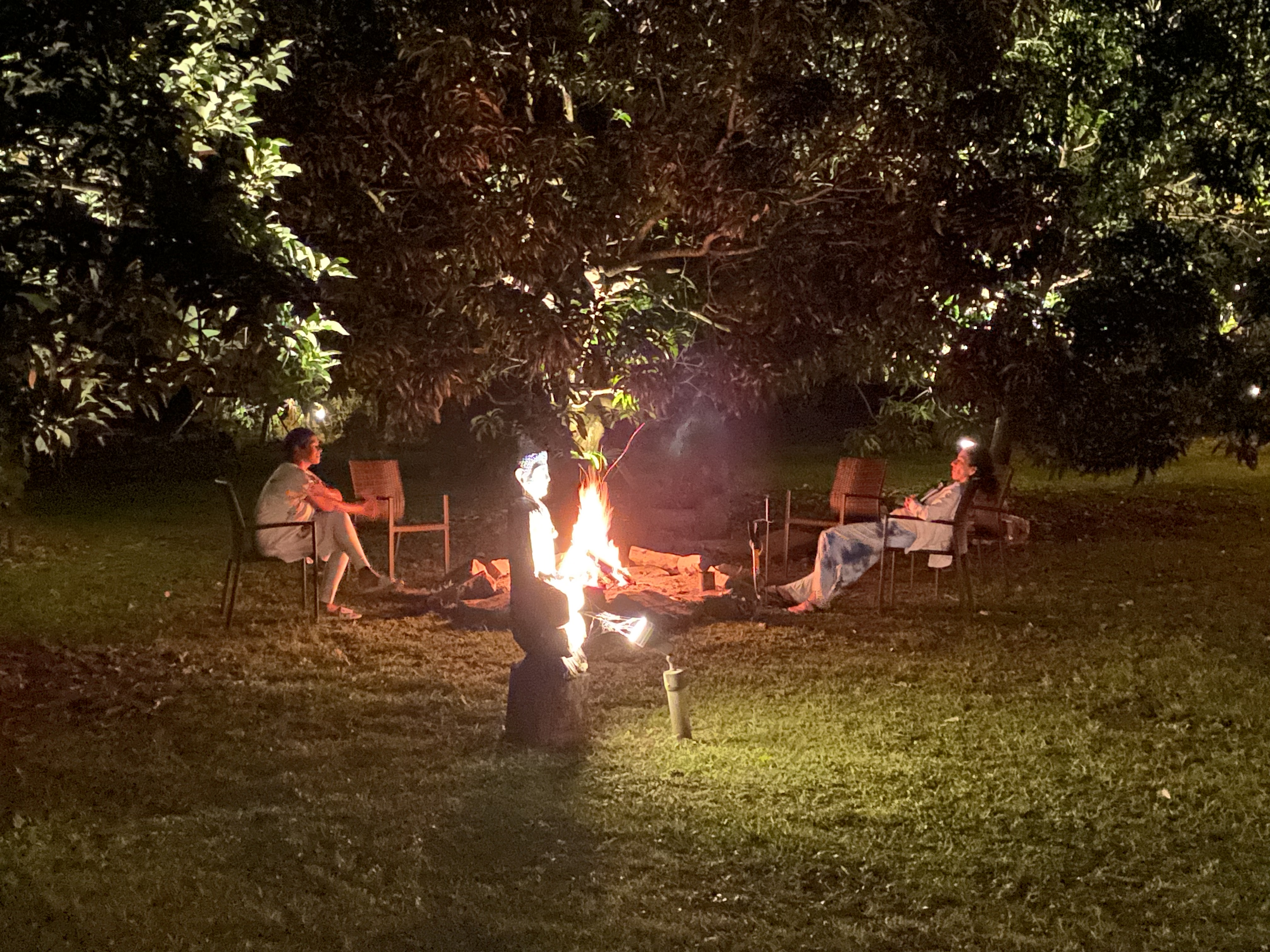 Members of the community sitting together around the fire.