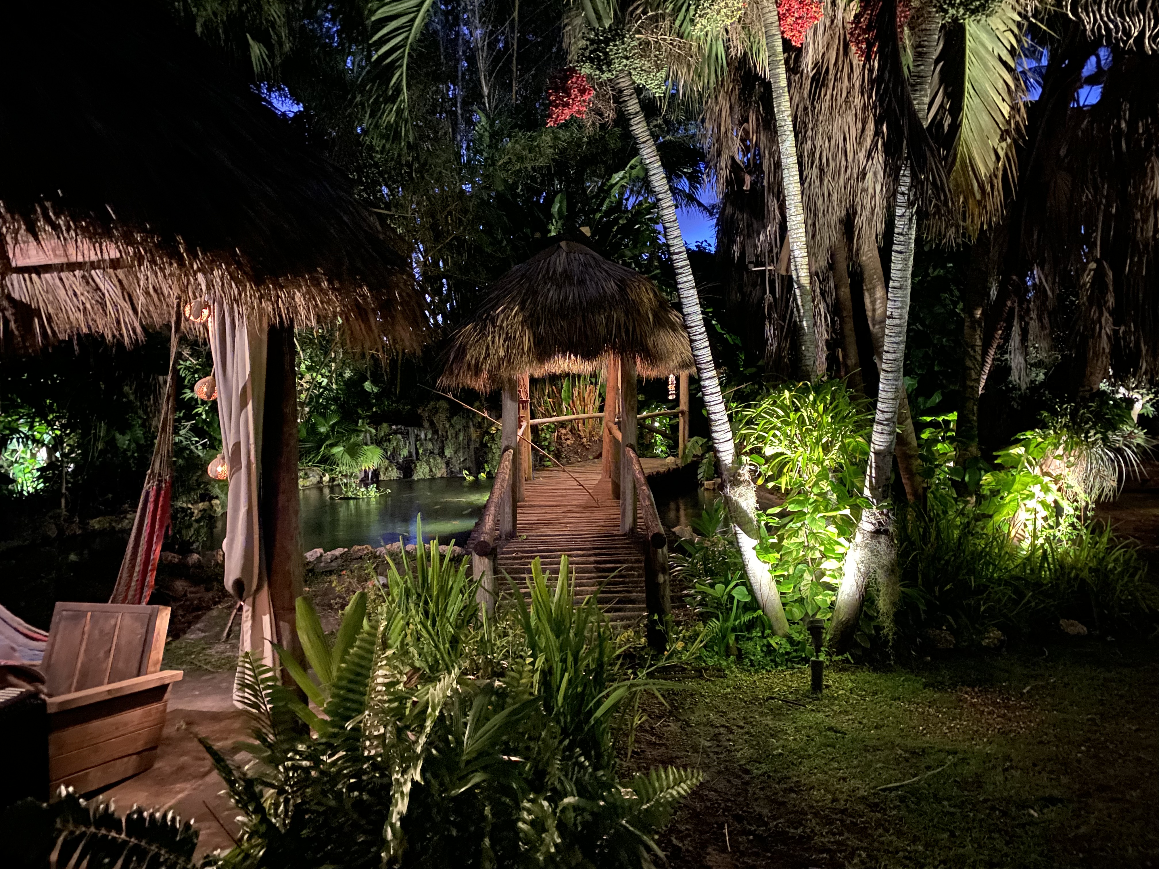 The tropical garden and pavilion illuminated after dark.