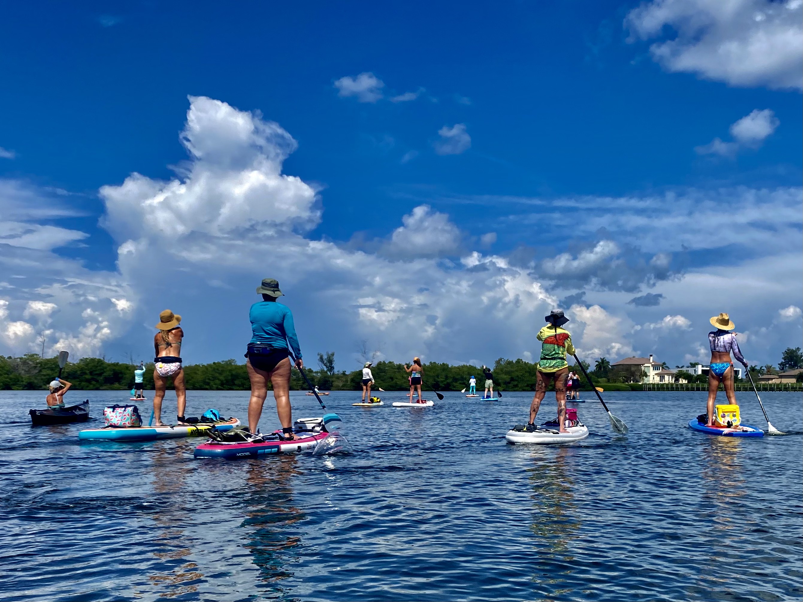 Paddlers under towering clouds