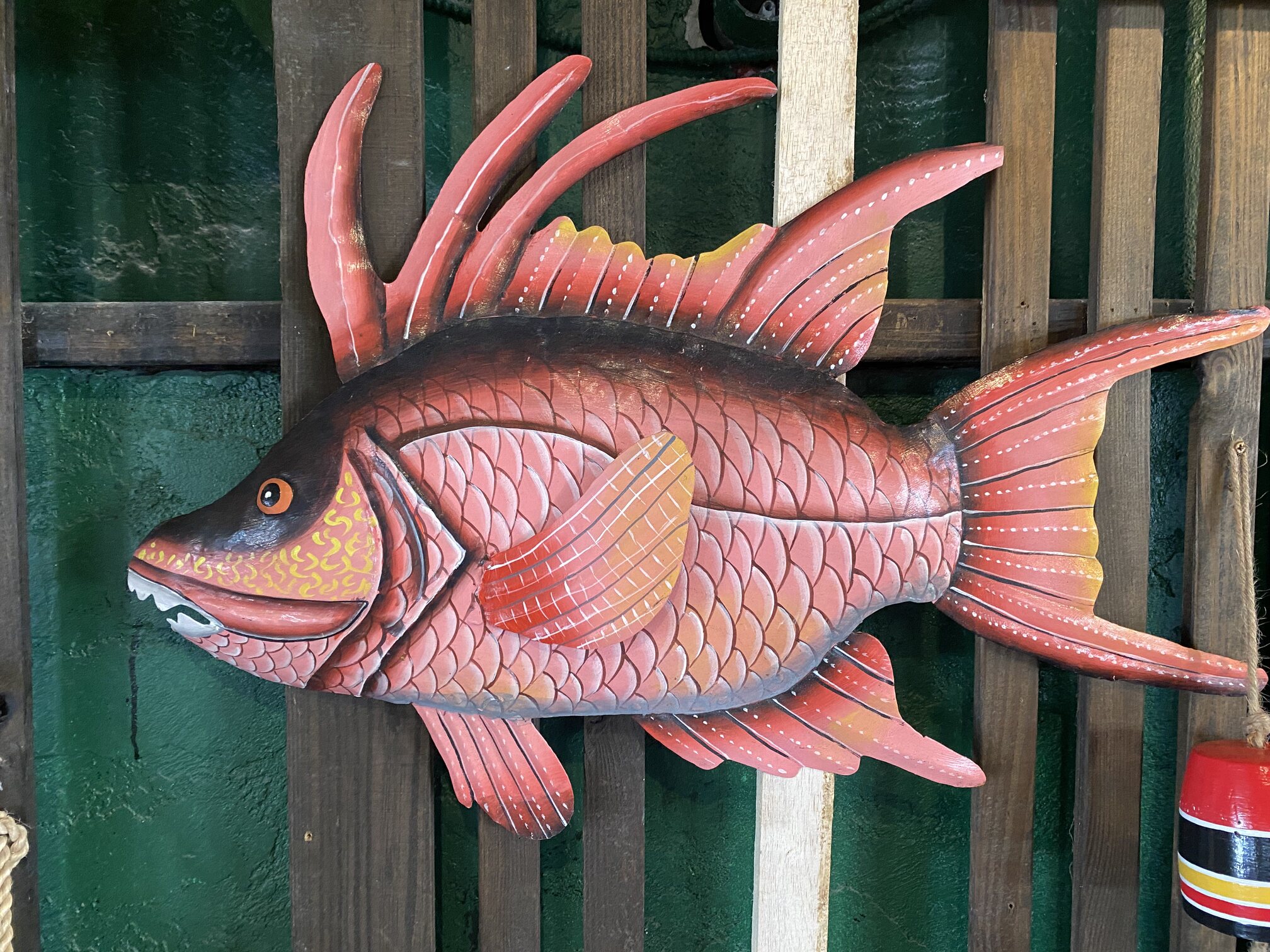 A carved tropical fish decorating a cottage wall.