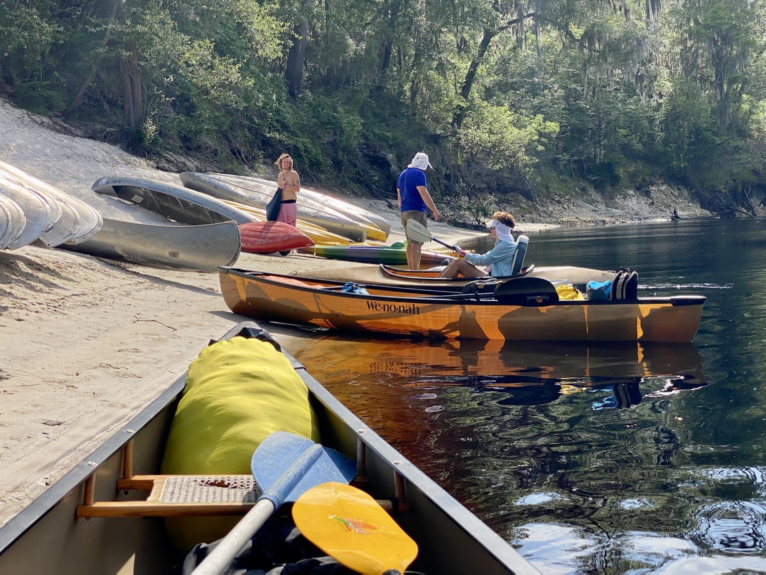 Kayaks and paddleboards pulled onto a sandy bank during one of our river stops.
