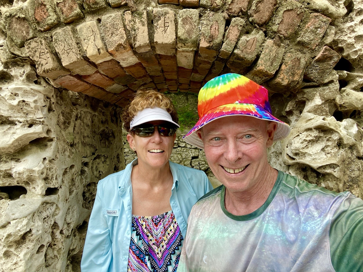 A cheerful riverside selfie beneath an old stone arch.