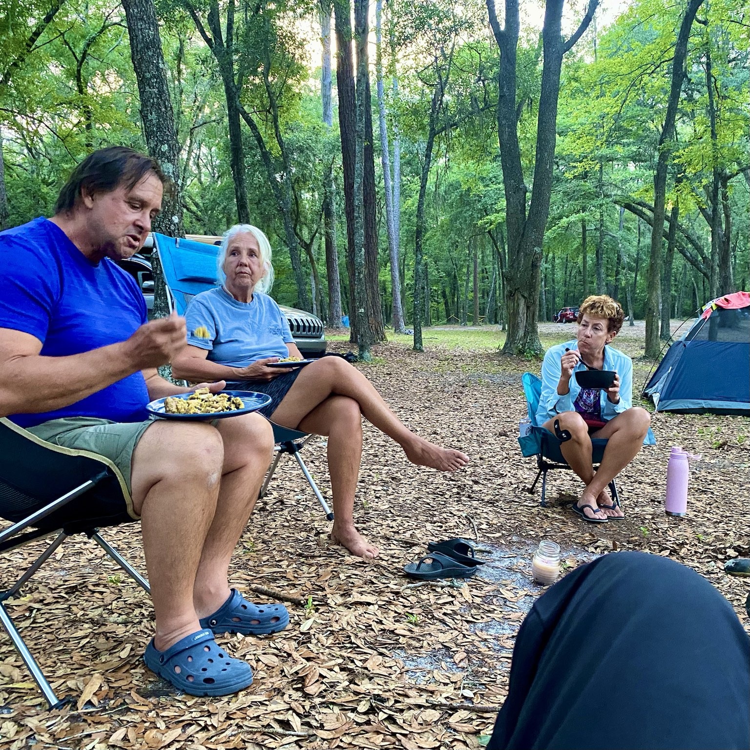 Relaxing together at camp beneath the trees.